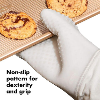 Silicone Oven Mitt in oat color holding a hot baking tray

